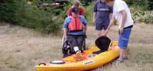 Paddle-Ability Clubs. Disabled child entering kayak.