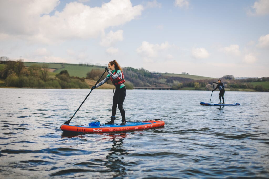 A young woman on a stand up paddle board