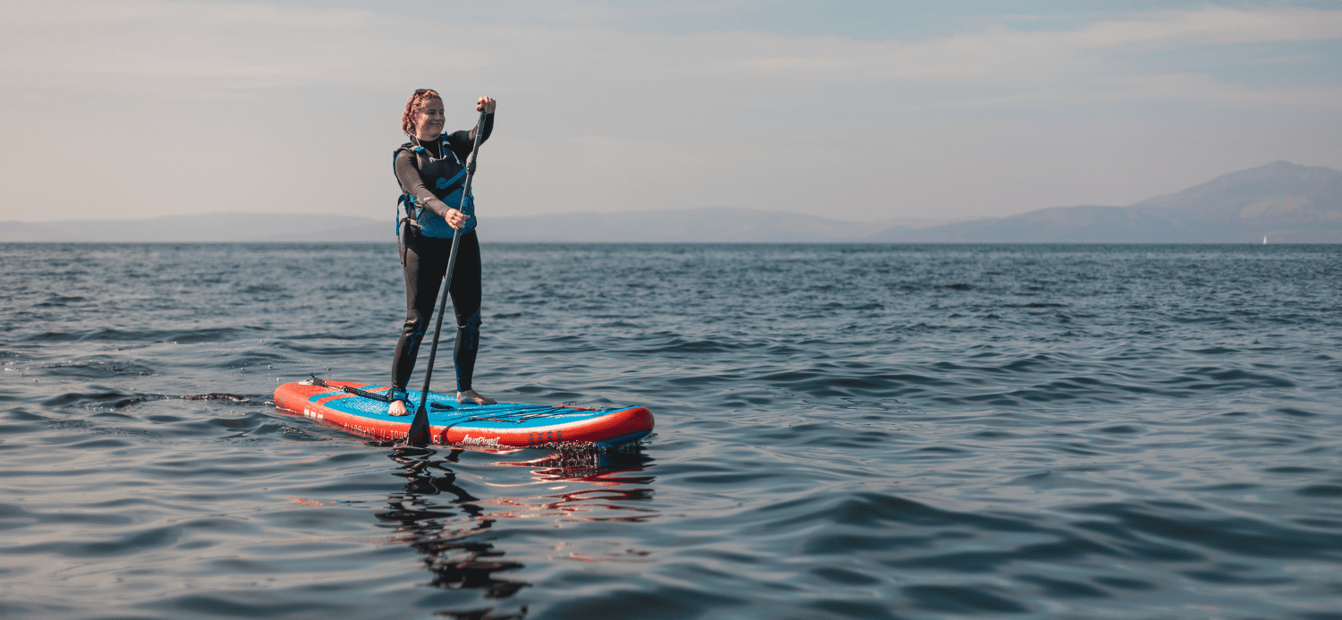 Female paddle boarding on the sea in the UK