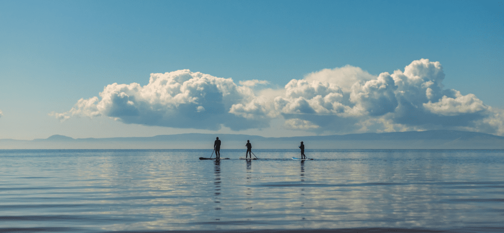 Family stand up paddle boarding on the sea in the UK