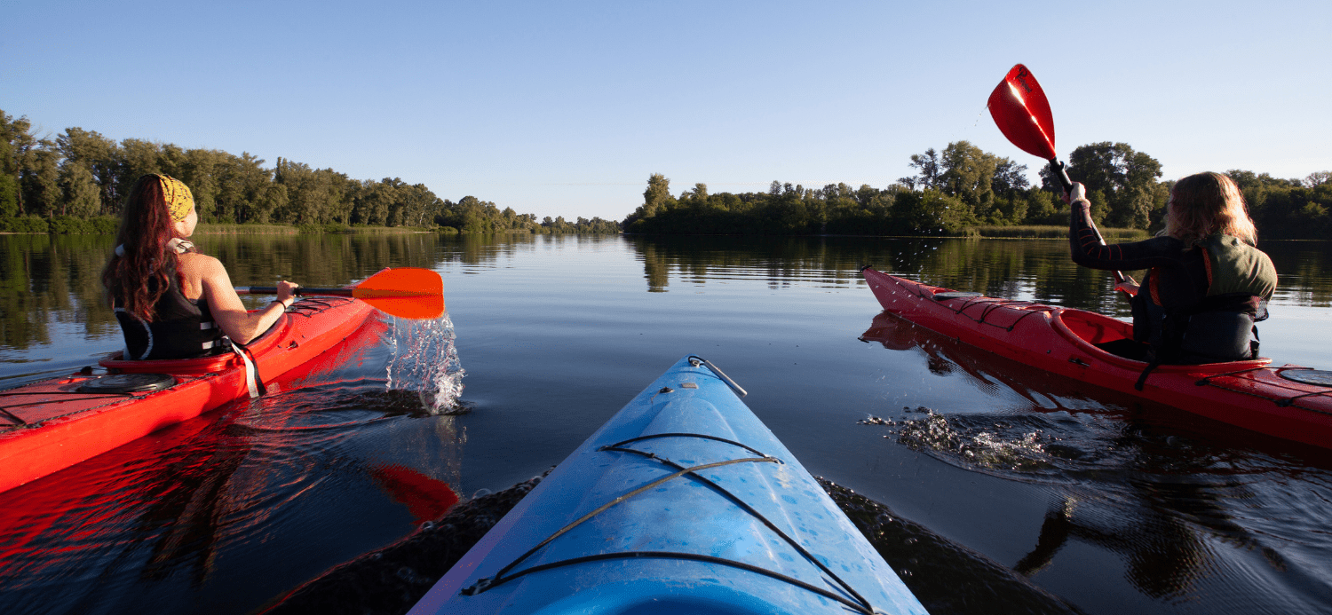 Group of friends learning to kayak on river