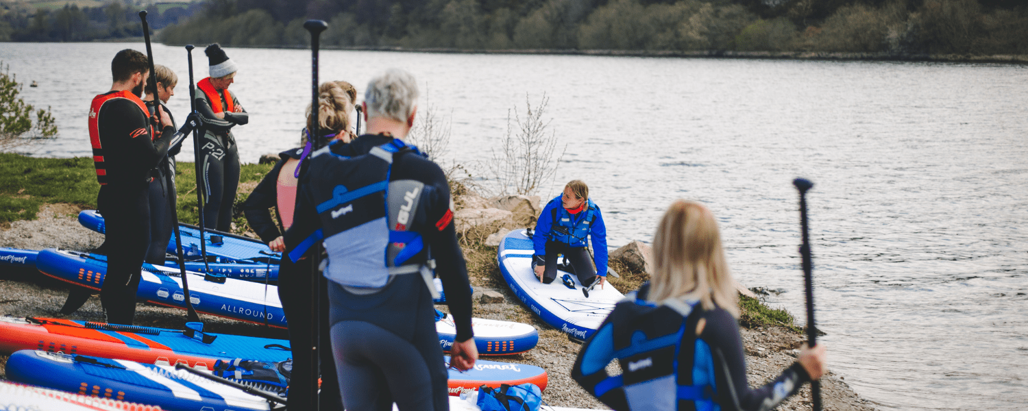 paddlers watching a coach give a demo on important skills