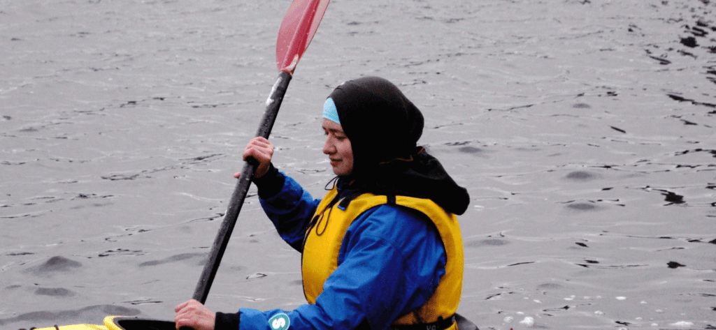 A muslim woman kayaking in appropriate head dress