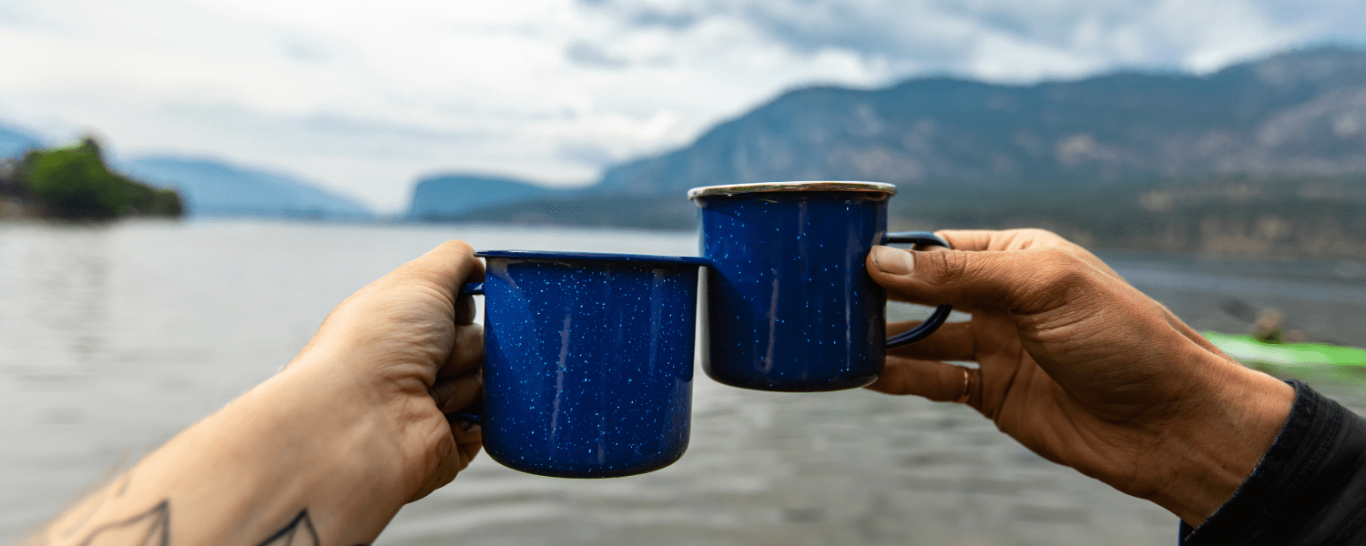 a set of coffee mugs connecting in front of a large lake