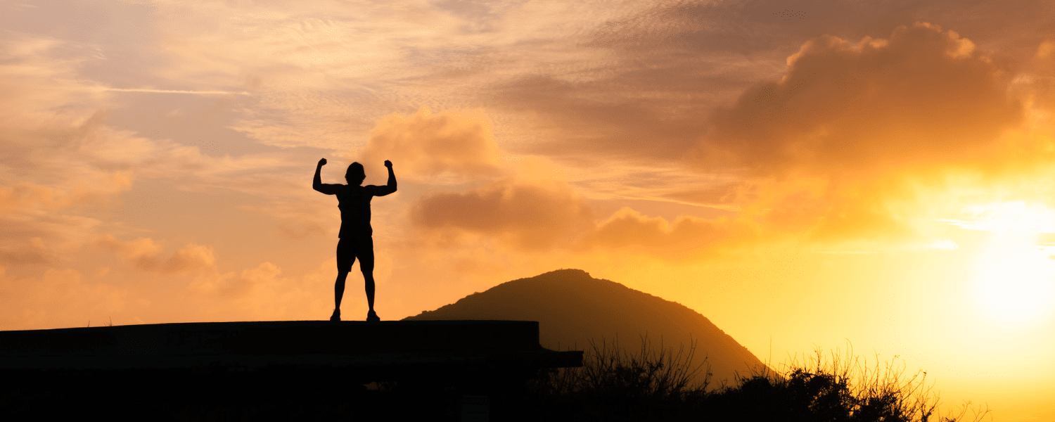 person on top of a hill at sunset feeling strong