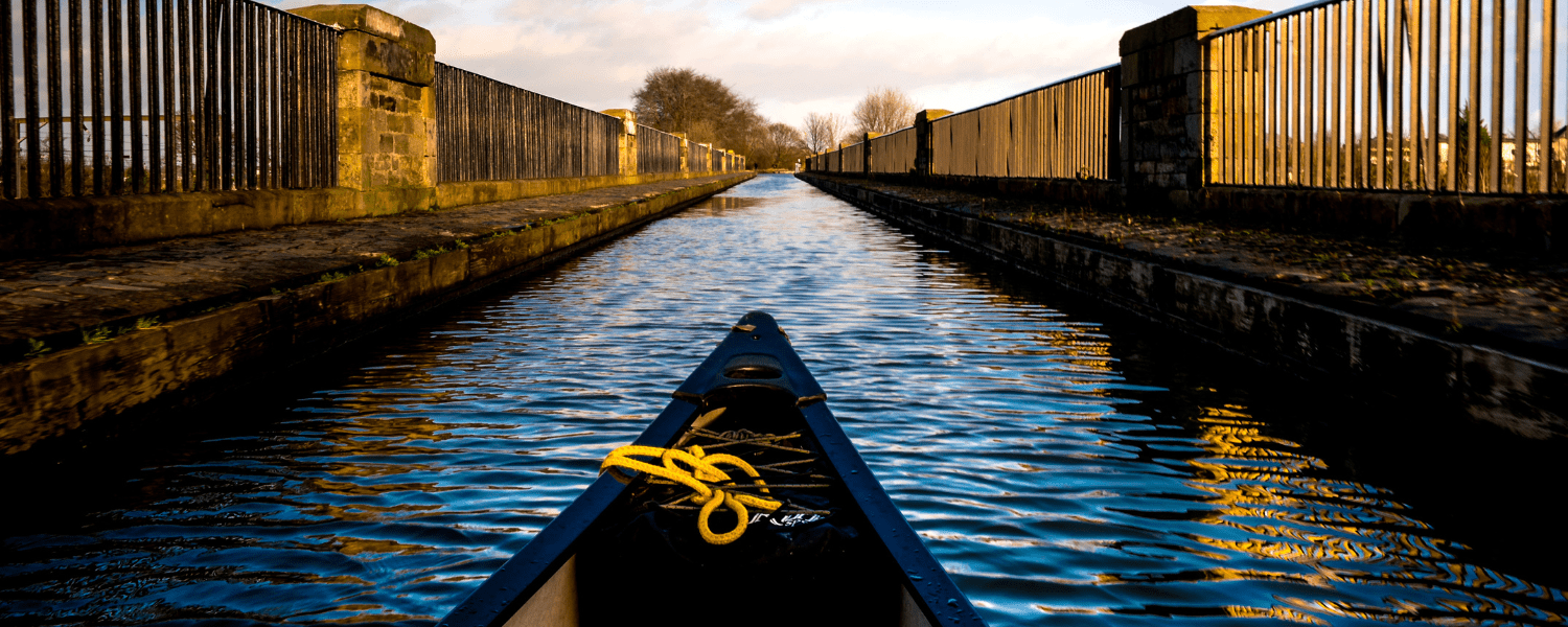 the bow of a canoe while paddling along a stretch of canal