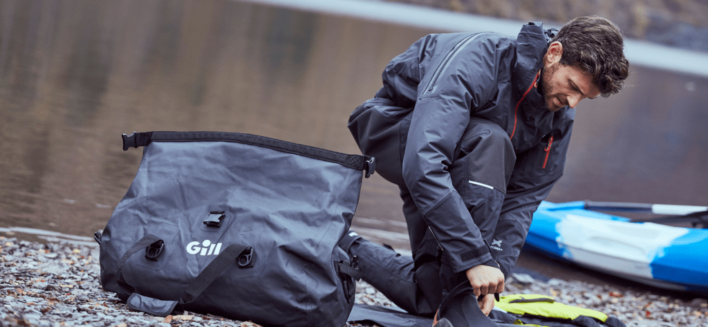 man getting changed into kit ready to paddle