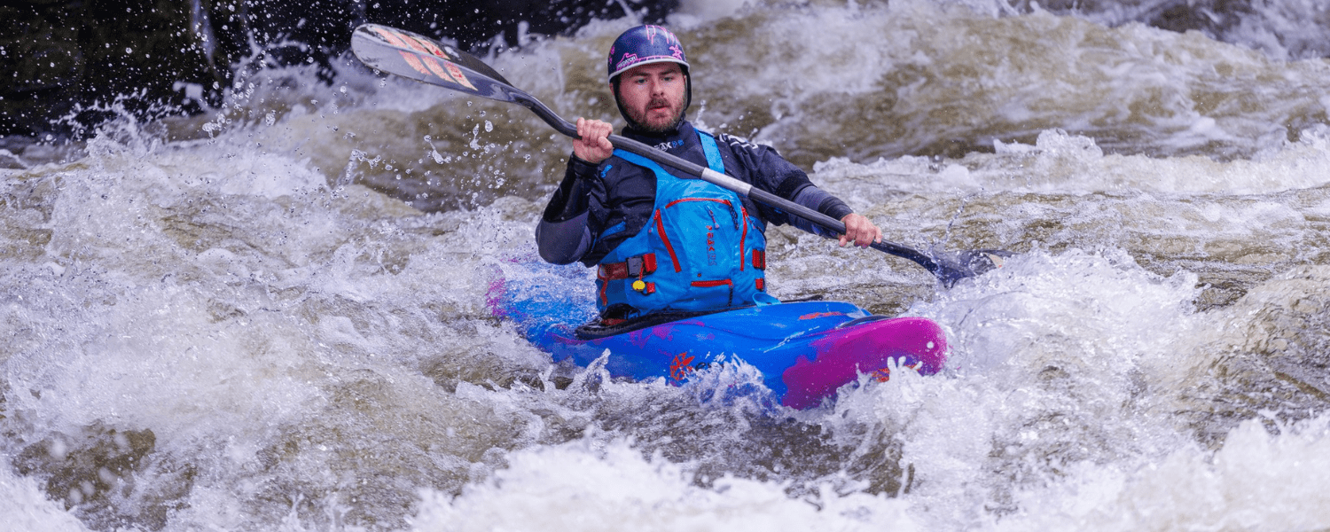 kayaker paddling down a section of whitewater on a river