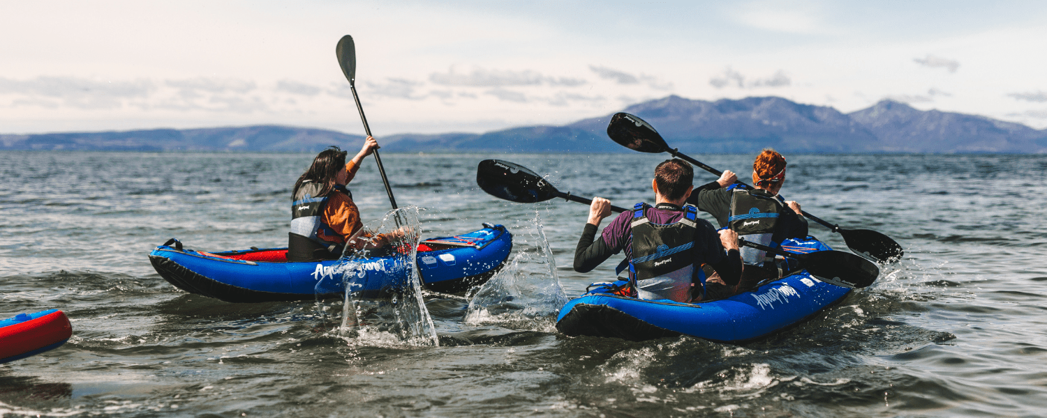 group of inflatable kayaks paddling out into a lake