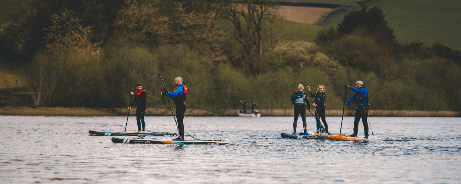 group of people on paddle boards in the middle of a lake