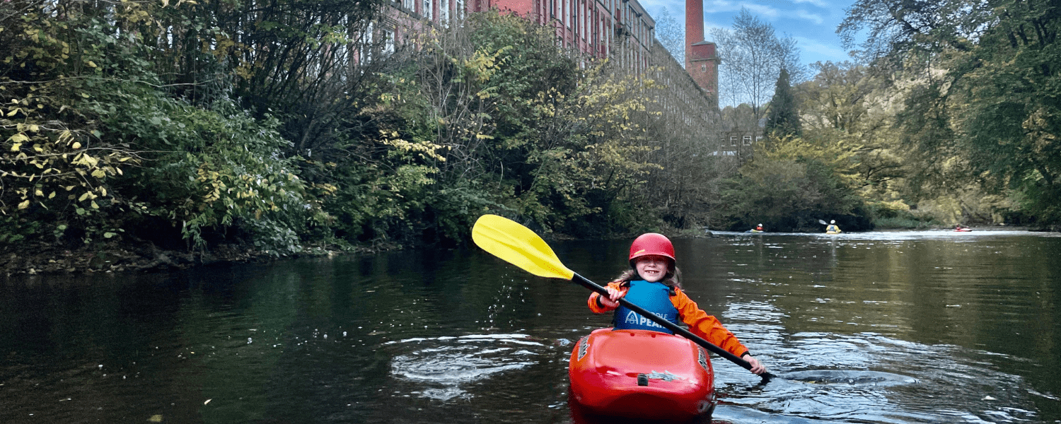 a young paddler making the most of the river that flows past an old mill