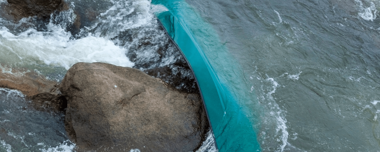 A canoe stuck on a rock against the flow