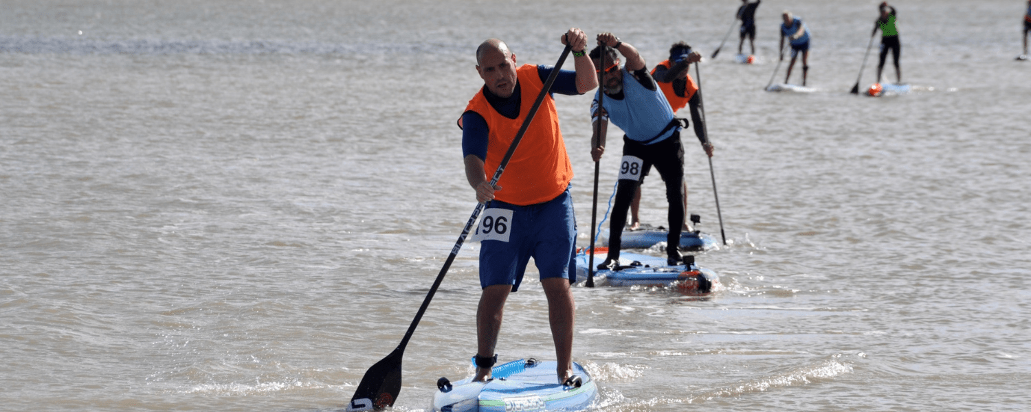 a line of paddle boarders in a race on flat water