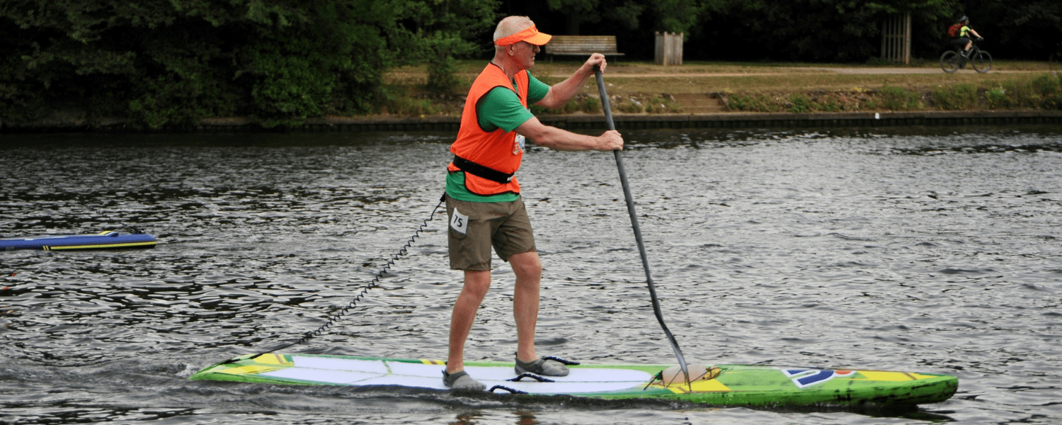 older man paddling in a sup race