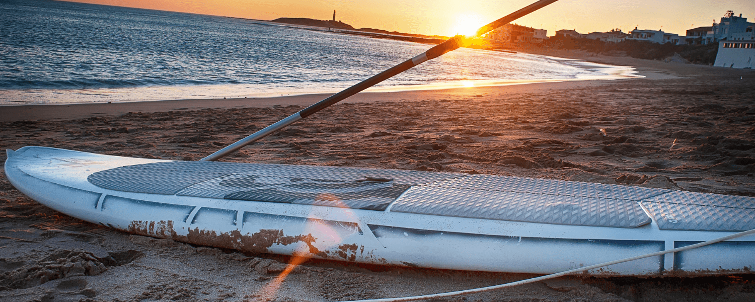 a paddle board and paddle alone on a beach