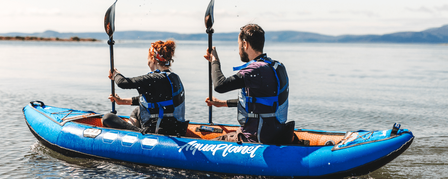 man and woman paddling together in an inflatable kayak