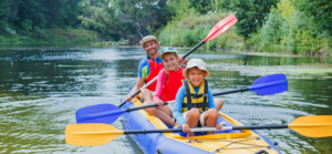 a man and two children enjoying time in an inflatable kayak