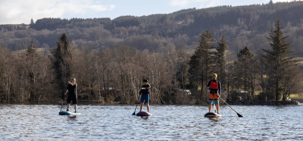 three paddle boarders paddling on coniston water