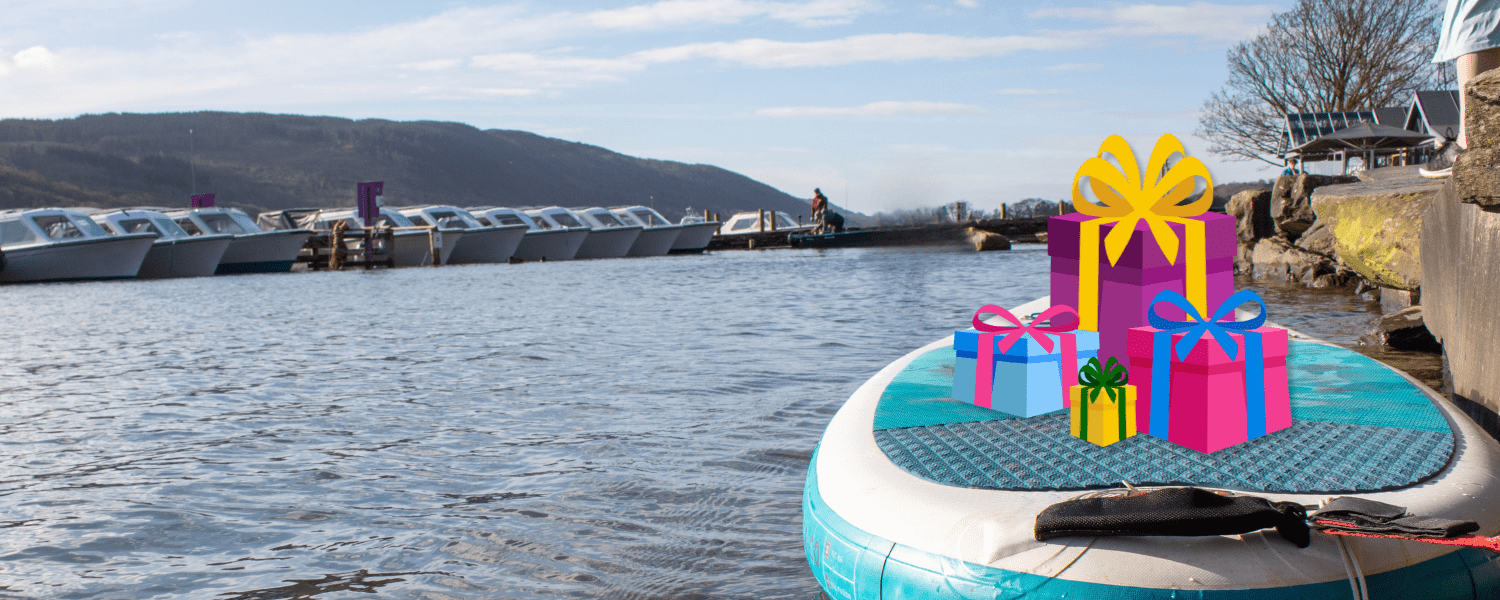 a paddle board on the water with a stack of cartoon gifts on