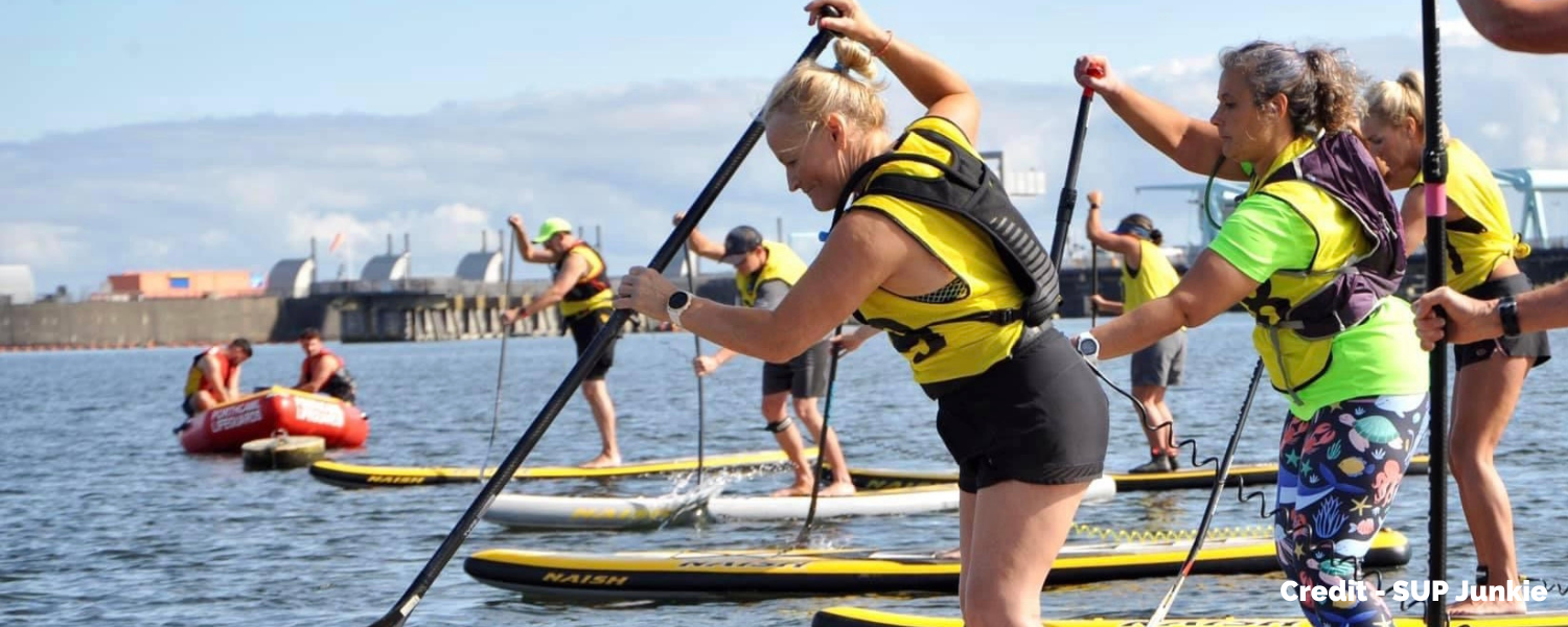 a group of women setting off on a sUP race