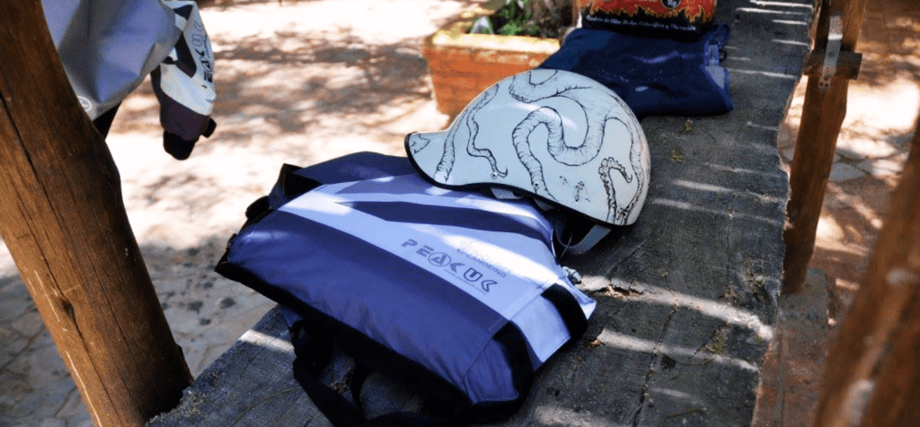 a buoyancy aid and helmet on a wooden bench