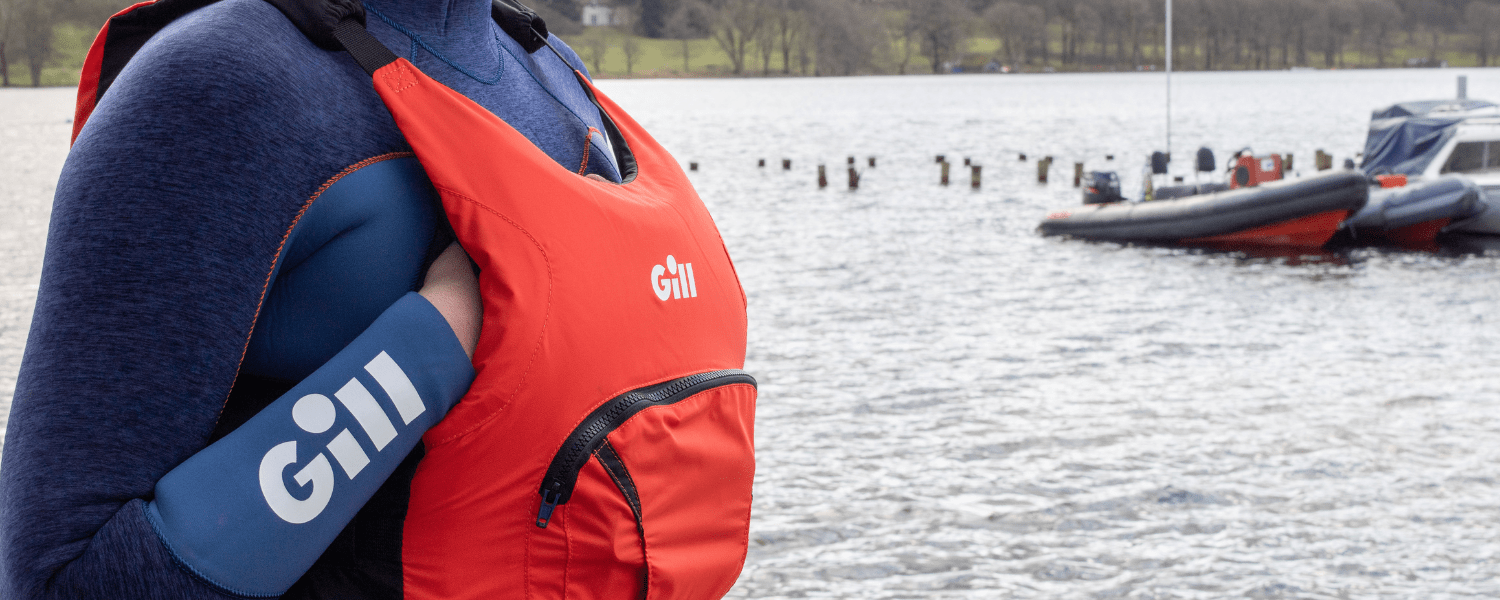 person stood in front of water water in kayaking kit