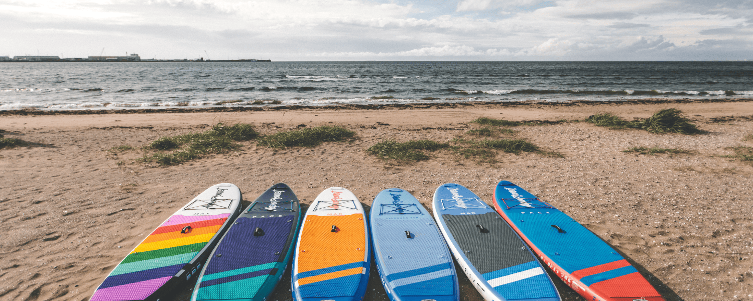 a group of paddleboards on a beach looking out to sea