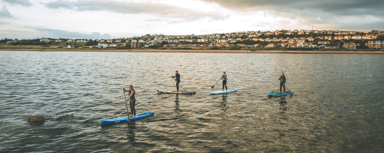 a group of SUP paddlers on the sea