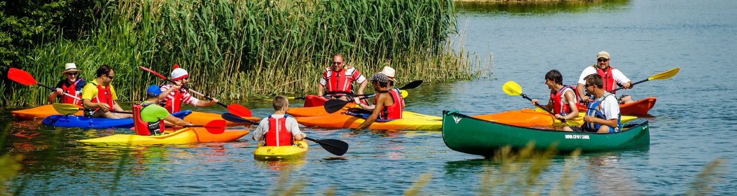group of people in kayaks and canoes